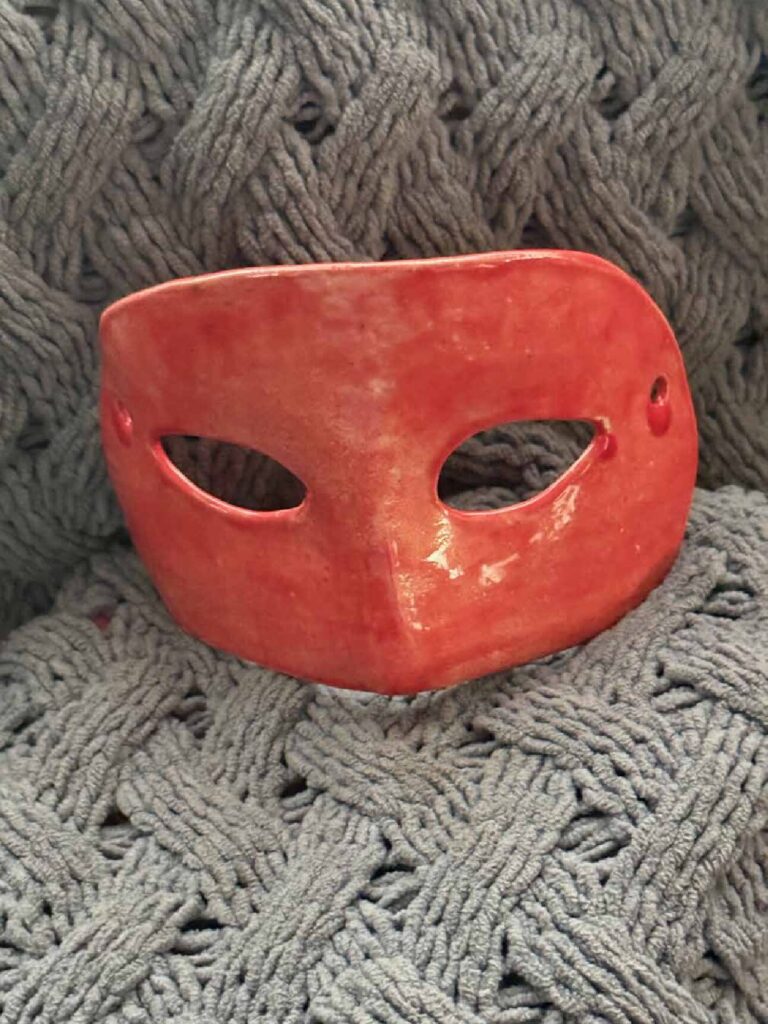 Handmade red clay masquerade mask with a lanyard