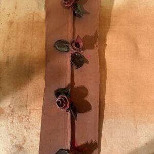 Decorative clay slab featuring four handcrafted roses with green leaves, showcasing artistic craftsmanship, ideal for pottery or art discussion.
