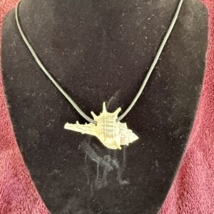 A detailed shell pendant on a black cord displayed on a dark mannequin bust, showcasing its unique design and texture.