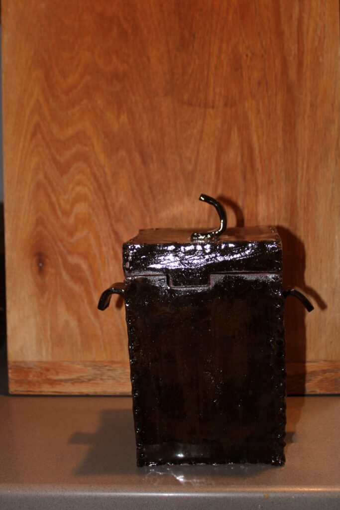 Square handmade ceramic canister with side handles in a glossy black glaze